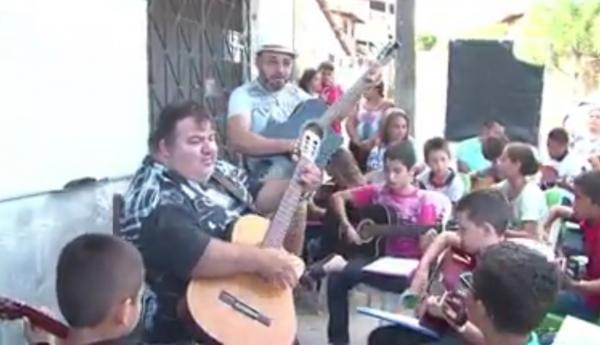 Professores ensinam música para crianças em calçada no interior do Ceará